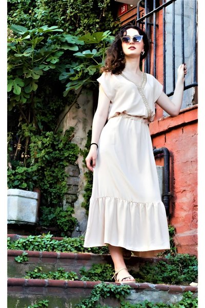 فستان طويل كريمي منسوج بياقة ملفوفة وكشكشة