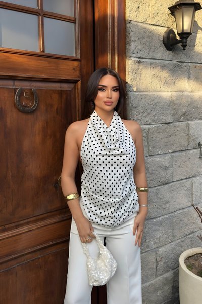 بلوزة بيضاء منقطة بياقة درابية تربط من الرقبة